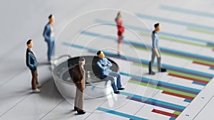 Business concept with miniature people standing on a graph.es